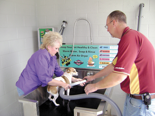 Scott Radford helps Debra Emory-Champlain give her dog, Jo-Jo, a bath Monday at the pet wash, a new portion of Radford's Car Wash facility on Highway 32-72 East.